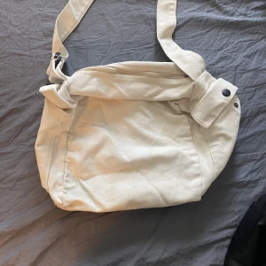 Vit skolväska  - Köptes juli 2022. Är lite nopprig men man får plats med många saker i den och den har tre fickor.