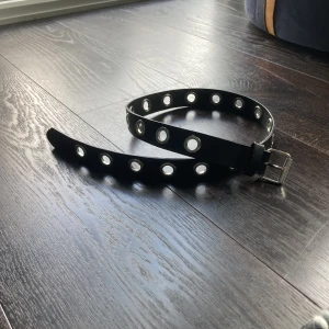 Skärp med öljetter - Sparsamt använt bälte med öljetter från H&M, köpt för 2 år sedan. Inga defekter alls och ser nytt ut. 20 hål så passar många!!! Kontakta mig med frågor/intresse!