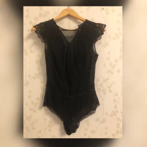 Spetsbody  - Body med fin spelt, V format i fram. Ingen spets ibak. Sparsamt använd 