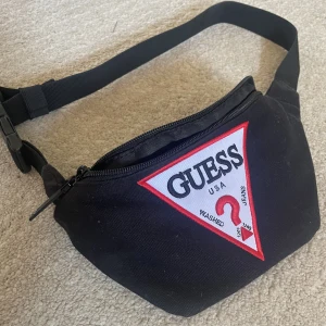Guess midjeväska - Säljer denna midjeväska från guess! Använd fåtal gånger, och endast damm på väskan så går enkelt att skölja bort! Pris kan diskuteras!