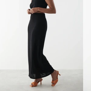 Svart maxi kjol - Svart långkjol från Gina, storlek xs. Superfin och helt slutsåld. Tunt skönt material, lite glasigt. Använd ett fåtal gånger, säljer för den tyvärr är för kort för mig som är 180cm. Kan mötas upp i Gbg eller skicka.   