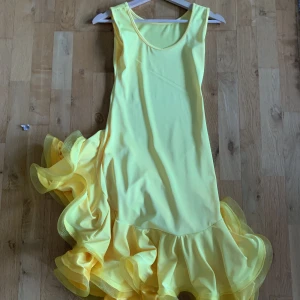 Dansklänning - En gul dansklänning från lightinthebox. Är i ett stretchiga material och når till ungefär knäna. Använt ett fåtal gånger. Skriv privat för flera bilder. 