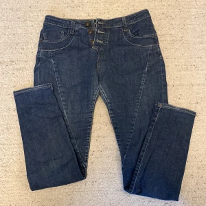 Blåa jeans  - Lågmidjade blåa jeans med hjärta på bakfickan. Toppskick och riktigt sköna. 