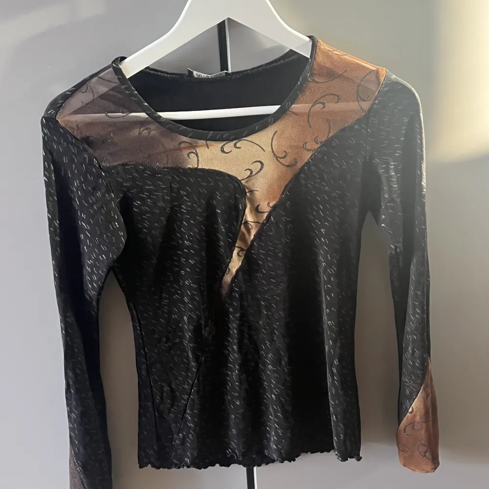 Snygg svart tröja med bruna mesh detaljer över bröst och armar. Toppar.