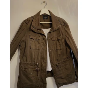 Olivfärgad jeansjacka  - Jeansjacka från Lindex. Resårband ovanpå fickorna därav går det att spänna åt för en tightare look. Bra skick, använt några gånger. 