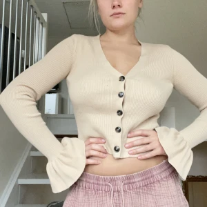 Beige cardigan - Beige cardigan från NA-KD. Använt ett få tal gånger men inga täken på slit. Har normalt storlek M men den passar mig ändå då materialet är stetshigt. 