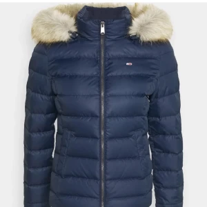 Tommy Hilfiger dunjacka  - Supersnygg och varm mörkblå dunjacka från Tommy Hilfiger. Fint skick, inga defekter! Nypris idag ca 1600 kr. Både luvan och pälsen går att ta av.