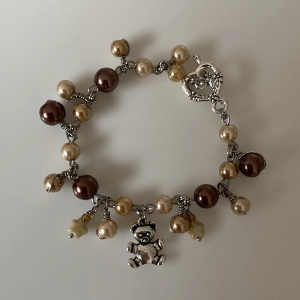 Armband med en teddybjörn berlock och glaspärlor i olika nyanser🐻🍁 frakt 15kr✨🍯. Accessoarer.
