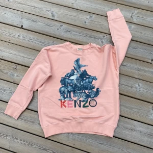 Kenzo, collegetröja - Superfin tröja från Kenzo. Rosa med tryck i blått. Strl 14 år, ca 150-160. I mycket gott skick! 