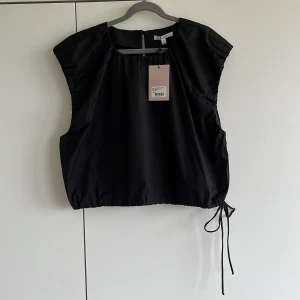 Ärmlös topp - Patty - Svart ärmlös topp från Dagmar. Nyskick, aldrig använd, lappar kvar. Storlek 42, för stor för mig så jag säljer. Bomull. Modellen heter Patty