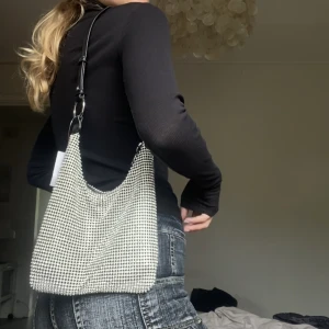 NY glittrig väska - Jättecool väska med stenar som ger härlig tyngd. Aldrig använd med prislappen kvar, nypris runt 400kr!! Köp nu eller skicka prisförslag🌷🌷