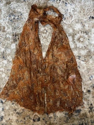 Halternecktopp med öppen rygg och glitter - Superfin festtopp med knytning i nacken, glittersömmar, pärlor och öppen rygg. Helt oanvänd.