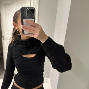 Svart kort polotröja - Säljer denna super fina svara korta polotröja som går att ha över många olika toppar. Använd endast ett fåtal gånger därför är den i väldigt bra skick 