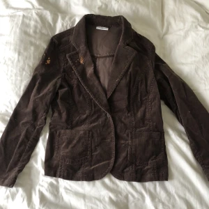 Brun Manchester kavaj - Brun Manchester kavaj med fjärilar i kopparpaljetter fram och bak på kavajen. 