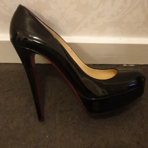 Louboutin klackar - Äkta Louboutin utan kartong, påse eller kvitto. i storlek 41. Rund tå och platå. Klackhöjd 14 cm och platå 3 cm. Kan skicka flera bilder. Passar mig som har storlek 40. Svart lackat läder. 
