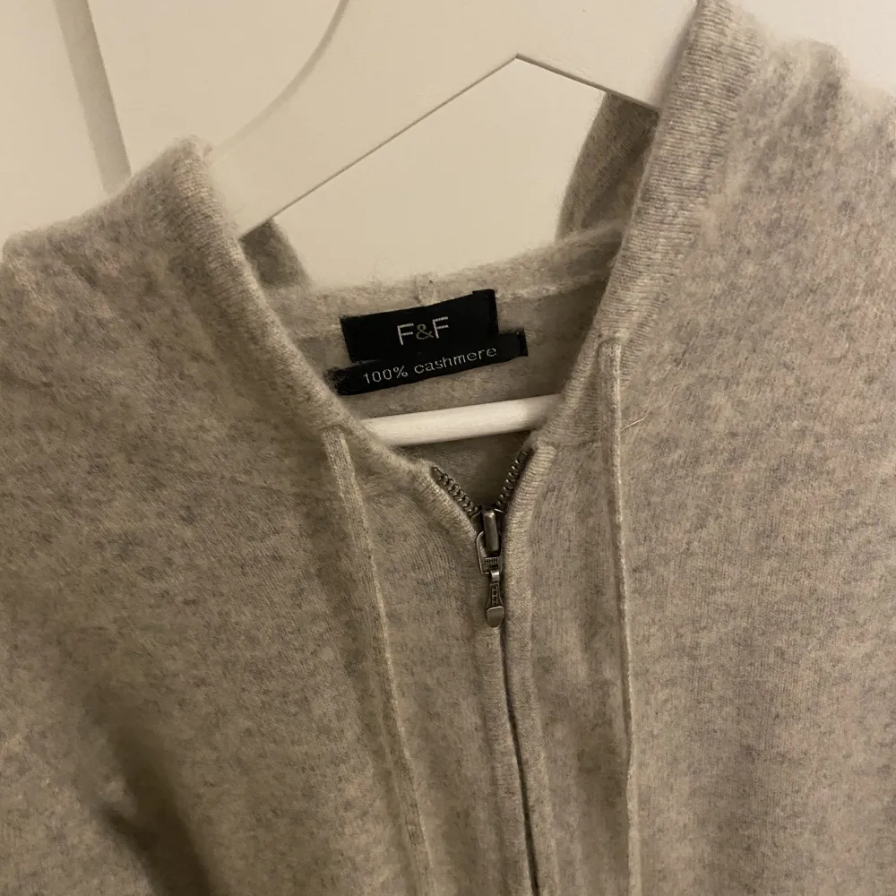 Säljer denna supermysiga Kashmir hoodien, grå/beige färg, bra skick, enda defekten är en liten lagning på armen men syns knappt. Tröjor & Koftor.