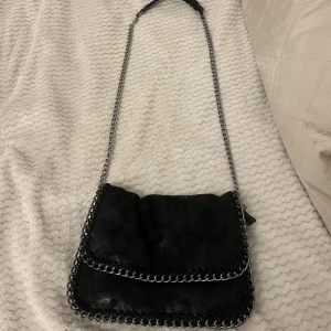 Väska  - Väska med kedjaband den är i glansig mocka material inga slitningar den är som ny Har flera fack som utrymmer med mycket saker  Nypris 850kr 