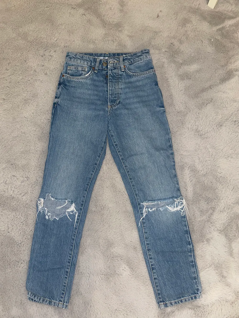Säljer ett par blåa jeans med hål vid knäna, dom är jättesköna och sitter bekvämt, säljer för dom är för små💙dom är ifrån weekday och sitter jättefint på . Jeans & Byxor.