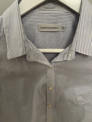 PeakPerformance skjorta - Ljusblå randig skjorta från PeakPerformance i perfekt skick, lätt figursydd.