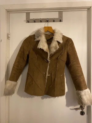 Päls/mockajacka - Varm sherlingjacka med päls inuti hela. Knappt använd, i bra kvalitet. Päls sticker ut vid kragen och ärmarna. Två knäppen framtill.