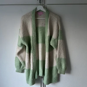 Stickad oversized kofta - Stickad vit/grön oversized kofta från Biancas kollektion med Nelly. Använd ett fåtal gånger och är i fint skick!  Storlek XS