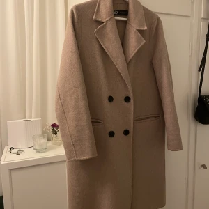 Oanvänd! Beige kappa från Zara - Beige kappa från Zara i storlek XS, oanvänd! Nyskick.