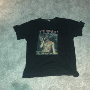 En svart t-shirt med ett tupac tryck på framsidan