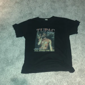 Tupac tröja - En svart t-shirt med ett tupac tryck på framsidan