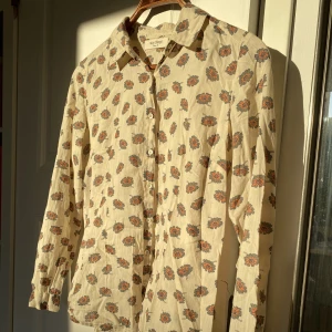 Blommig skjorta/blus - Supersöt skjorta köpt på secondhand, i så fint skick🌼🌼 Så fin att ha med en tjocktröja över så kragen syns! Säljer då den tyvärr inte kommer till användning längre.