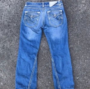 True religion jeans - Säljer nu mina Trueys. Måtten är Midja 46 cm Längd 104 cm Benöppning 24 cm De är i fint skick enda som jag kan påpeka är att lappen bak sitter lite löst och lilla fickan fram har lossnat lite i kanten. Annars fint skick!