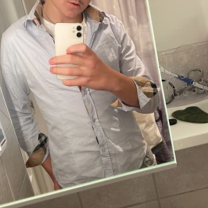 Burberry skjorta - Vad jag vet är den äkta! Köpte den  här på plick och han visade äkthetsbevis. Den är liten liten dock för mig så vill göra mig av med den. Använd 1 gång INGA DEFEKTER!!  Skick 10/10