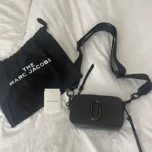 Säljer min snapshot Marc Jacobs väska i svart. Nyskick, mycket plats och mycket fack. Dustbag och äkthetsbevis tillkommer. Nypris 4300 kr, säljer för 3500 kr. 