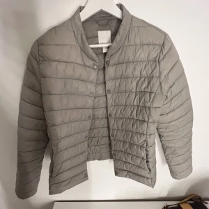 Beige dunjacka - Beige/grå jacka från Hm. Storlek 40, passar S/M Använt skick, finns defekter (skriv för bild). 