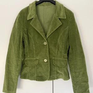 Mossgrön manchesterkavaj - Superfin ofodrad kavaj i manchester Armlängd: 60, bredd: 43, längd: 60 Stängs med två gröna knappar i plast. Fickorna är endast dekorativa! Ingen etikett eller tvättlapp som indikerar märke, men i superbra kvalitet och perfekt skick❤️‍🔥 färg som sista bilden