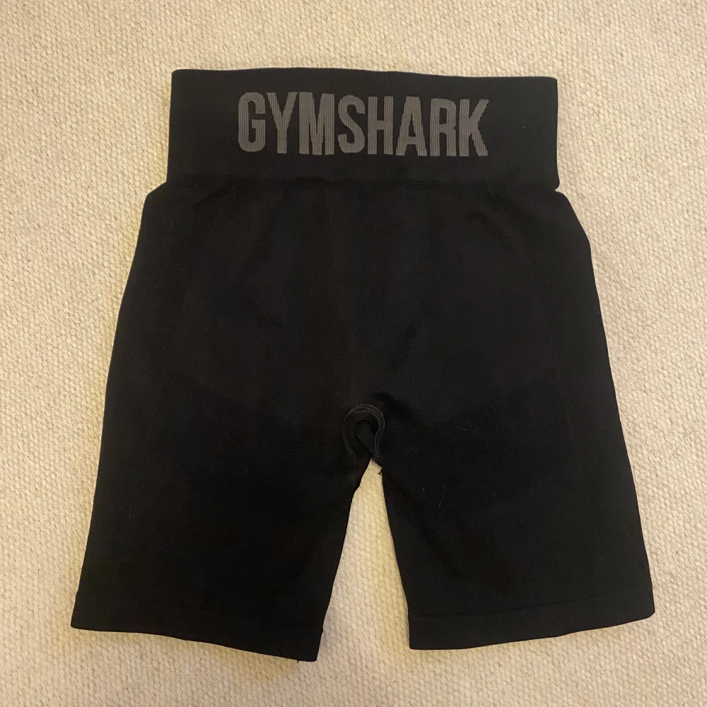 Ett par riktigt snygga shorts med stor Gymshark text på baksidan. Säljer pga att jag rensar garderoben och märkte att dessa inte kom till mest användning! Skick 8/10. Inget fel på dem alls, man ser dock att dem används någon gång tidigare 🤗budgivning!. Shorts.