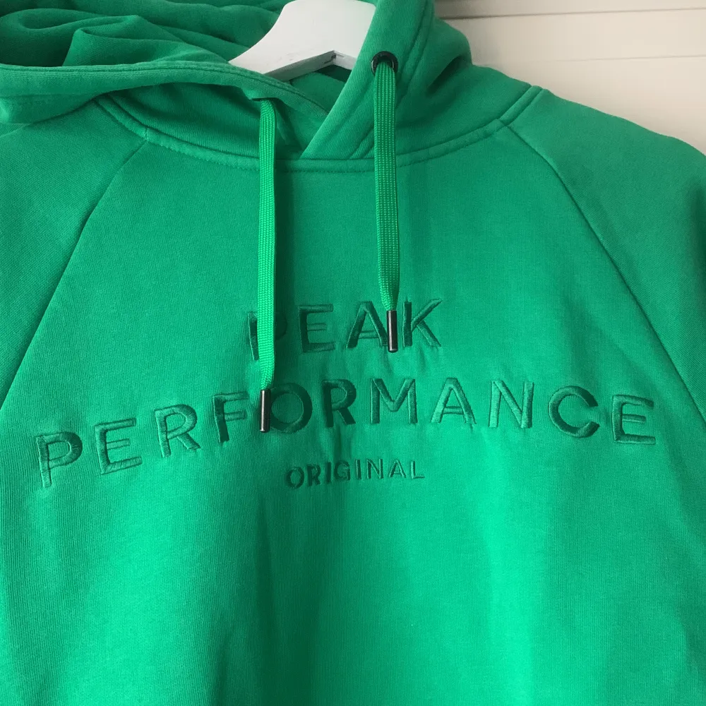 Grön Peak Performance - hoodie med luva och en ficka vid magen. Luvan har snören som är uttagbara. Mycket fint skick och mycket varm. Storlek L. . Hoodies.