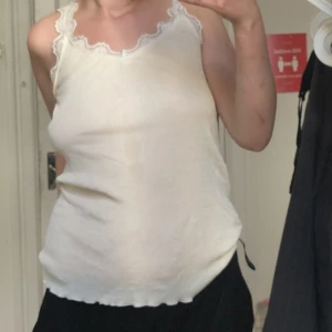 Vitt linne med spetskanter  - Supersöt vitt linne med spetskanter, har typ en fläck mitt på men man tänker inte på den, köpare står för frakt:) 