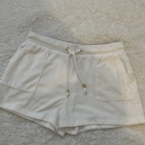 Vita shorts - Vita shorts med fickor och små gulddetaljer som inte är använda av mig då de var aningen för stora, passar stl xs-m.