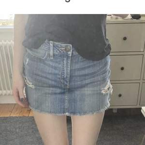 Kort jeanskjol från Abercrombie med slitningar. Strl W25 men passar mig som normalt har S