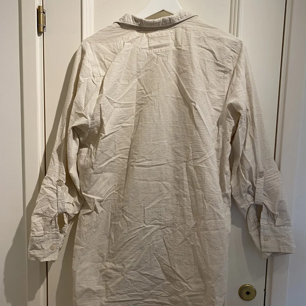 Mysig och skön nattskjorta från Primark, stl. 38, som räcker ovanför knäna. Begie-vit randig. Knappt använd. Ärmarna går att vika upp och fästa med en knapp.  . Skjortor.