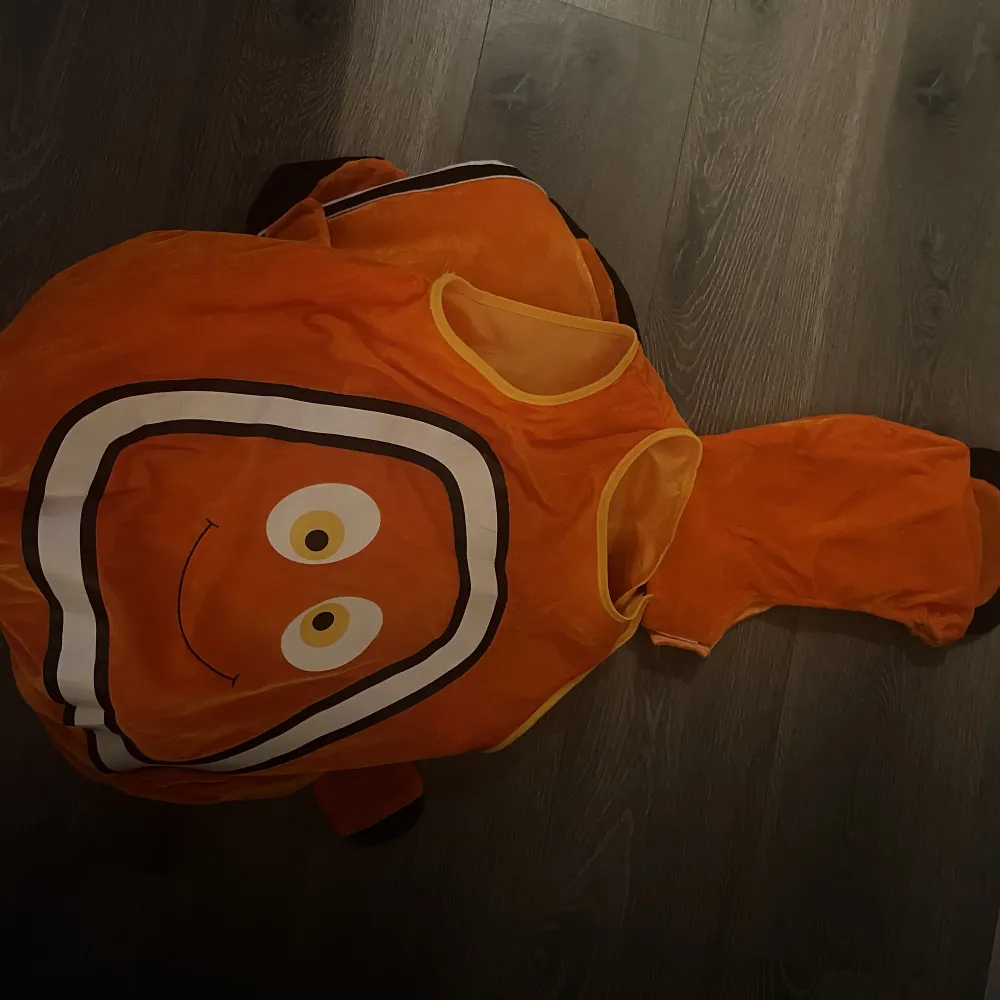 säljer en oanvänd hitta nemo kostym som skulle varit till en maskerad men kom försent. de är en oklar storlek men de passar både till barn och till mig som är 21 år som en tröja. Den kostar 500 ny . Muu.