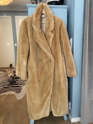 Fuskpäls beige - Fuskpäls i fint skick, går att tvätta i tvättmaskin och är tvättad. 