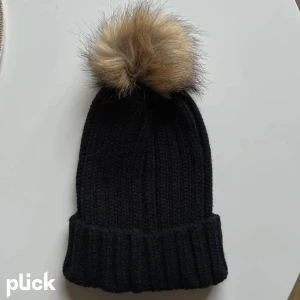 Mössa - Från Gina tricot med fuskpälsboll. Grovstickad men i mjukt material, inte stickig. Aldrig använd och därmed i nyskick!