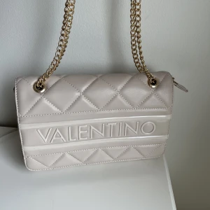 Valentino väska - Jättefin väska i nyskick där dustbag tillkommer. Orginal pris: 1500kr  Längd på rem: 26.5 cm Mått: 26,5 x 16 x 10cm Bredd: 16cm 