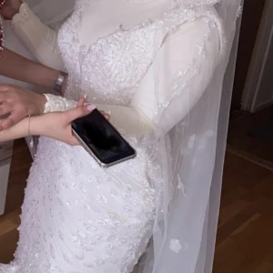 Brudklänning med släp och brudsjal - Superfin brudklänning som är ”mermaid-modell” med ett stort släp som går att sätta på och av,  ärmarna är påsydda och man kan ta bort de. Passar strl M-L och det finns band som man justerar på klänningen med bakifrån.