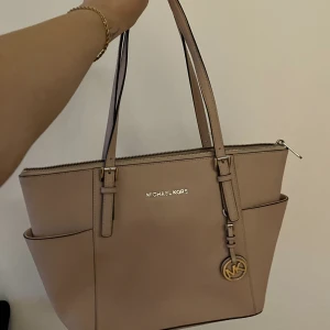 MICHAEL KORS designer handväska - Begagnad mellanstor Michael Kors handväska i en ljusrosa färg 💗