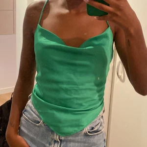 Grön satin top - Denna snygga satin top i grön är från ginatricot. Knytning där bak. Storlek 34