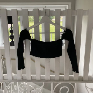 Ribbad topp - Kort ribbad topp med offshoulder armar. Superfint skick.  Står att det är strl M men skulle säga att den passar en S också!