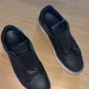 Axel arigato laceless 360 sneaker svart i läder - Svarta Axel arigato 360 sneakers i läder i stl 43. De är i befintligt skick. 