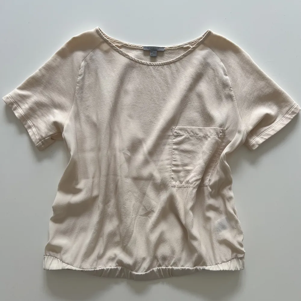 Cremevit/ljusbeige t shirt med ficka från Cos i nyskick 🤍. T-shirts.